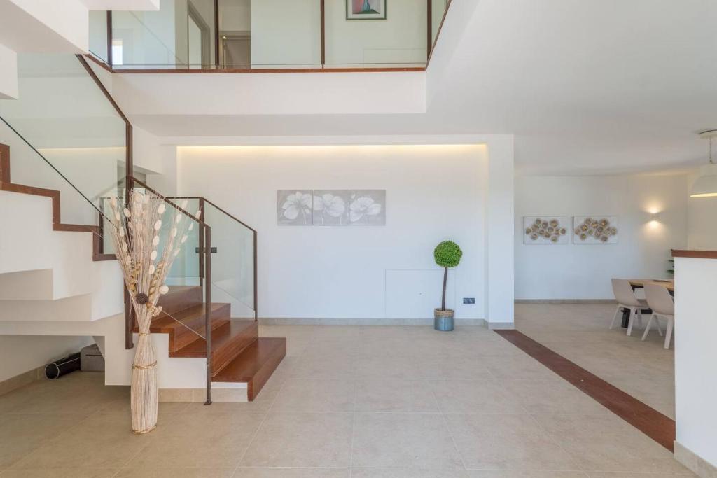 a living room with stairs and a potted plant at Sa Font in Lloret de Vistalegre