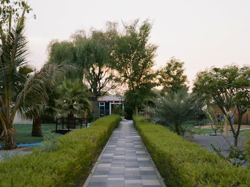 a walkway through a park with trees and a building at Seven Elements Resort in Ras al Khaimah