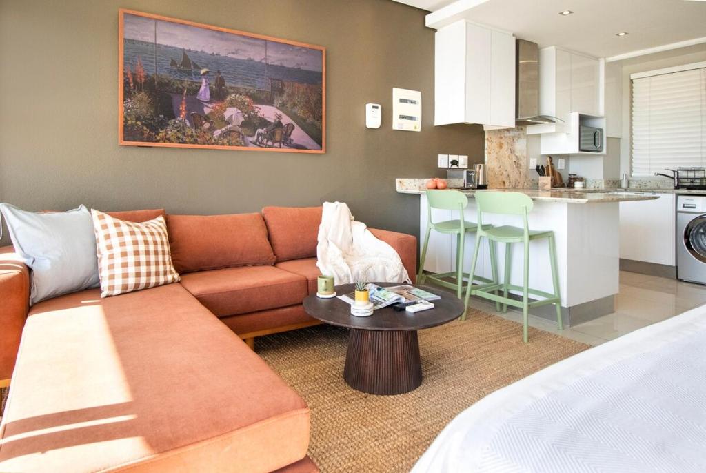 een woonkamer met een bank en een keuken bij Sonvanger Studio at Andringa Mall Luxury Apartments in Stellenbosch