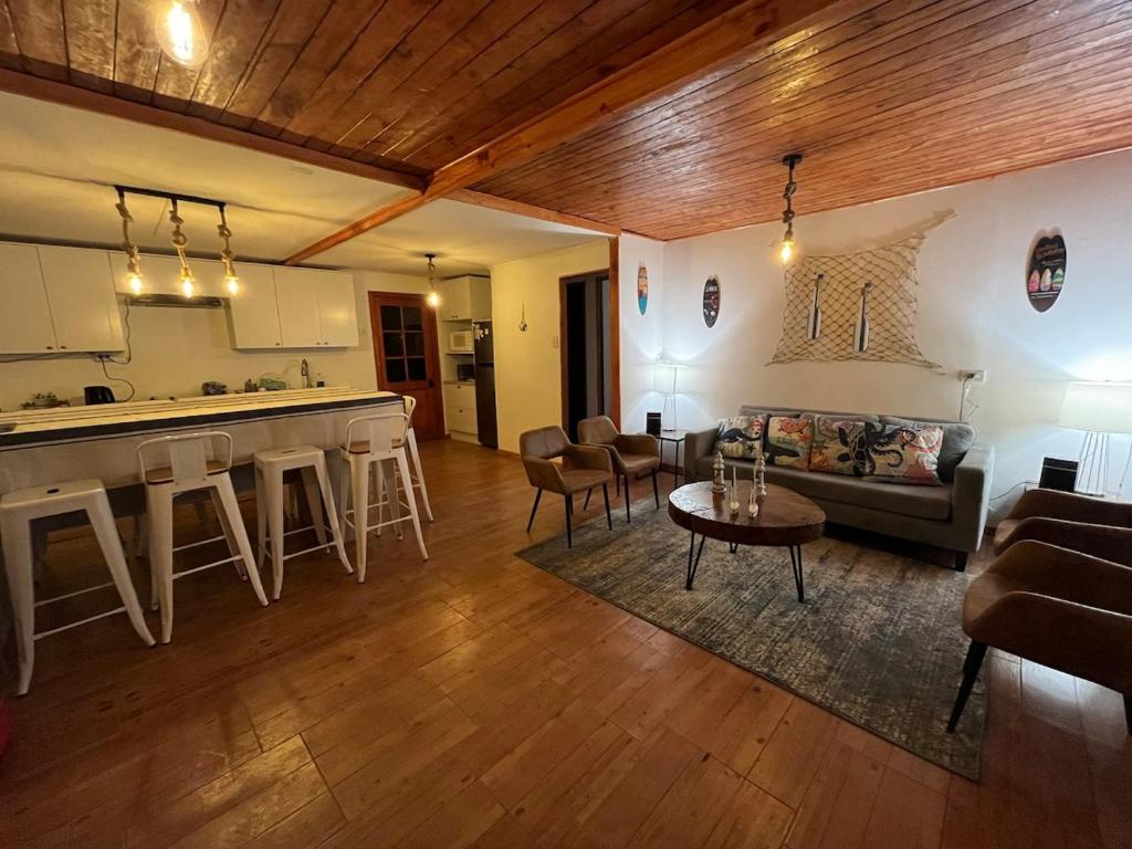 a living room and kitchen with a couch and a table at Maitencillo, amplía y cómoda casa, con piscina y hoy tub in Puchuncaví