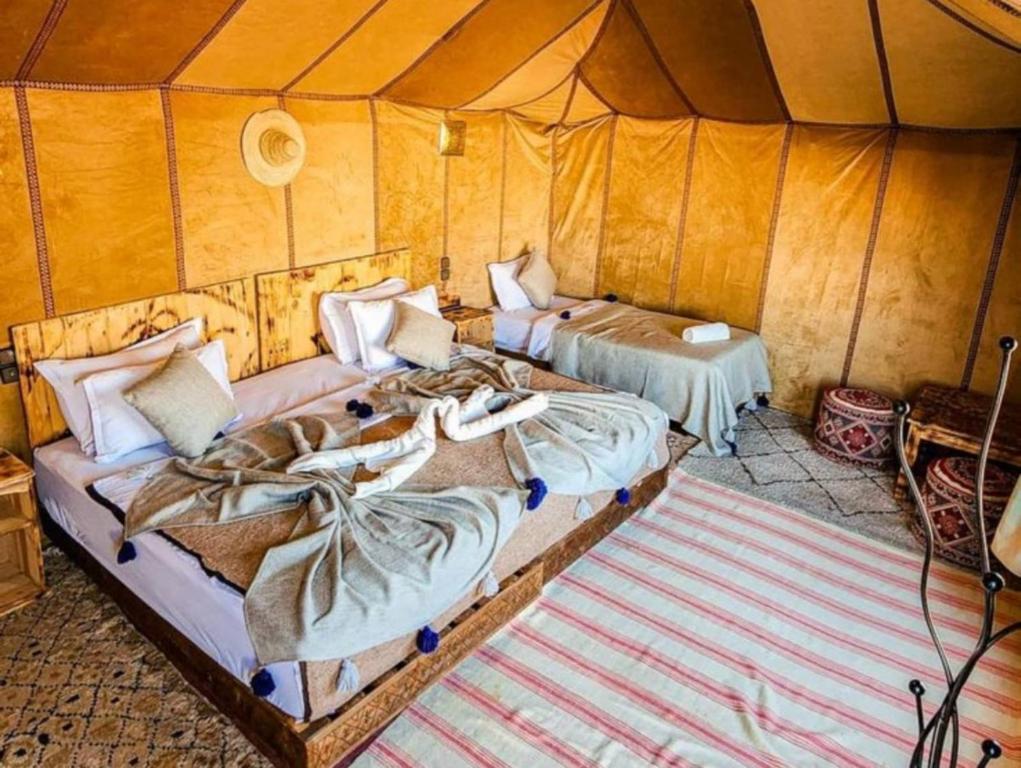 梅尔祖卡Oasis Desert Luxury Camp的帐篷里有两张床的房间