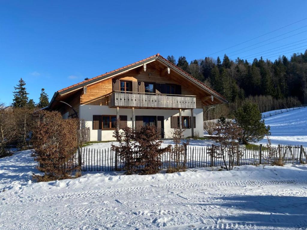 een huis met een hek in de sneeuw bij Chalet Fluh in Schindelberg