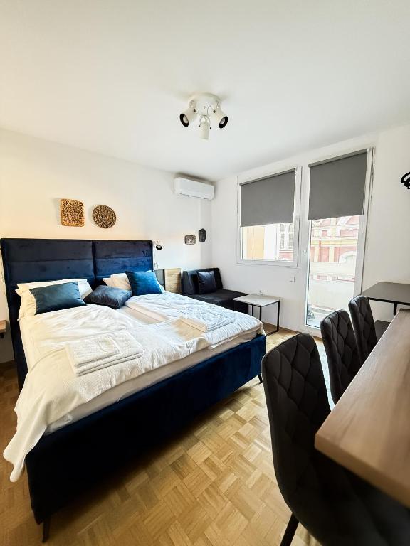 a bedroom with a large bed and a couch at Ma Bel Apartments Sarajevo in Sarajevo