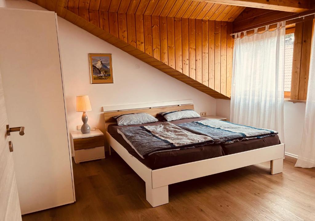 PürgenにあるFerienwohnung Alpenblickの木製の天井のベッドルーム1室(ベッド1台付)