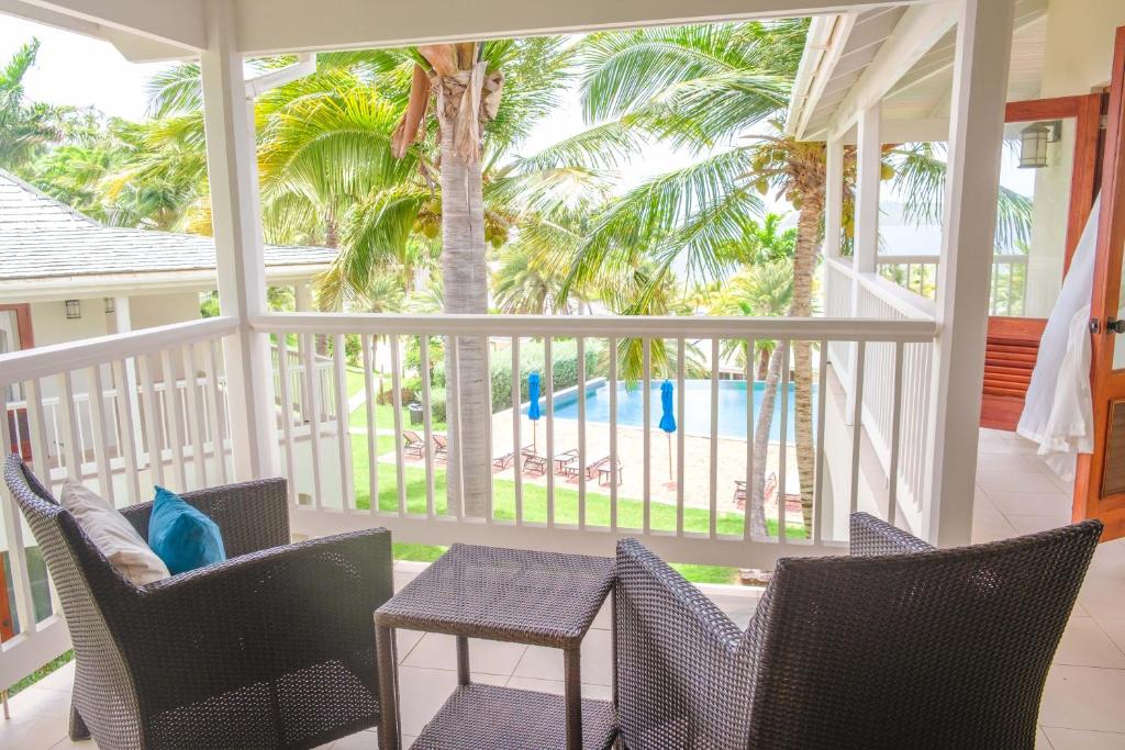 The BrookにあるTropical Escape1511の椅子とテーブルとヤシの木が置かれた網戸付きのポーチ