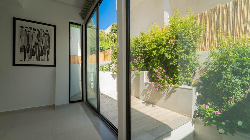 an internal view of a house with glass doors and flowers at Aurora Piscine Chauffée à quelques pas de la mer in El Haouach