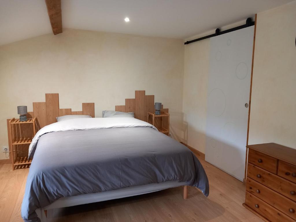 a bedroom with a large bed and a wooden dresser at Chez Delphine in Doizieux