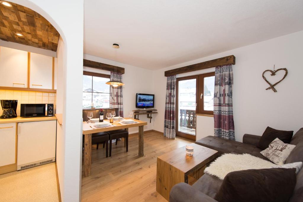 a kitchen and living room with a couch and a table at Angelas Appart in Ehrwald