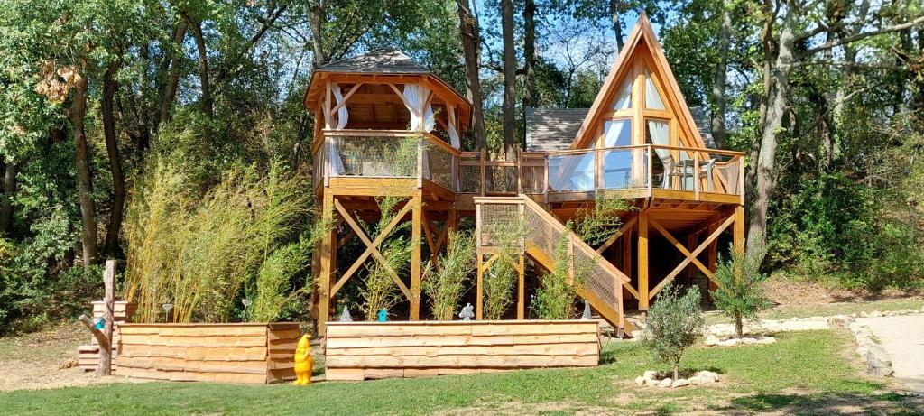 une cabane dans les arbres au milieu d'une cour dans l'établissement Les cottages de Sarrant, à Sarrant