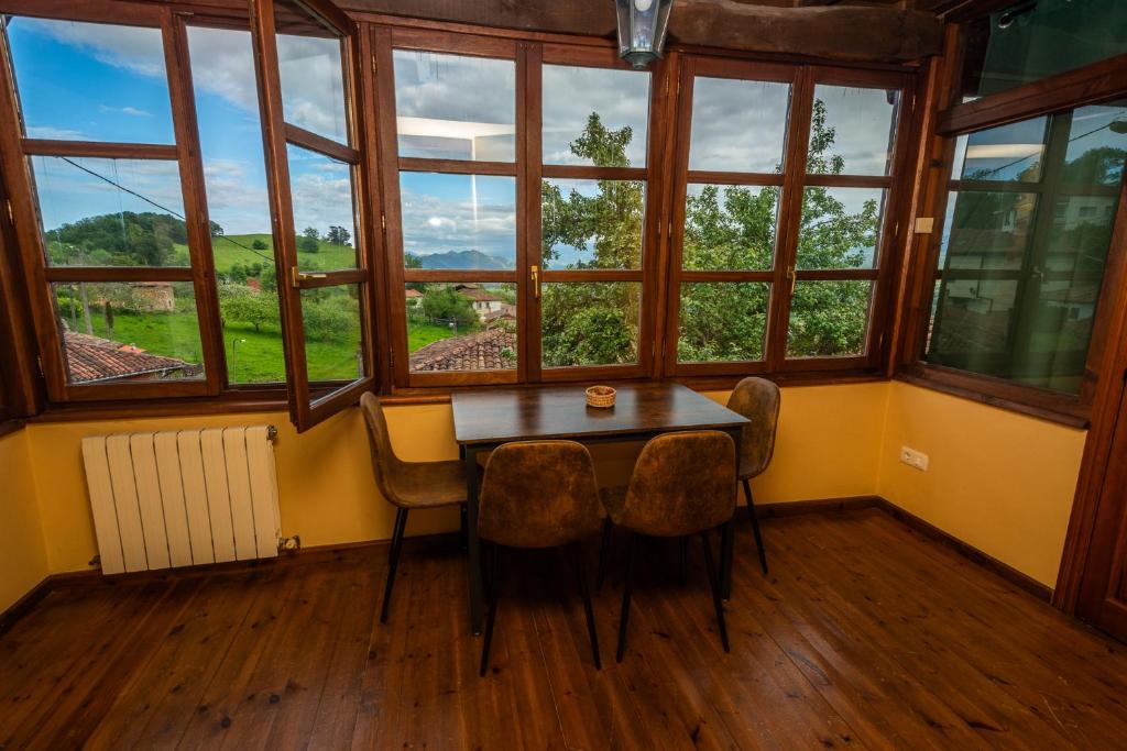 a table and chairs in a room with windows at Casa Horno in Robledo