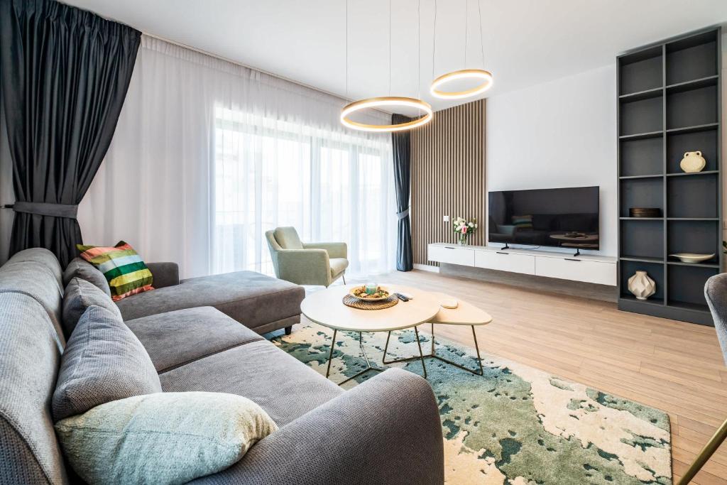 un salon avec un canapé et une table dans l'établissement Spacious 2BR Apartment - with Balcony and View, à Vatra Mînăstirii Cotroceni