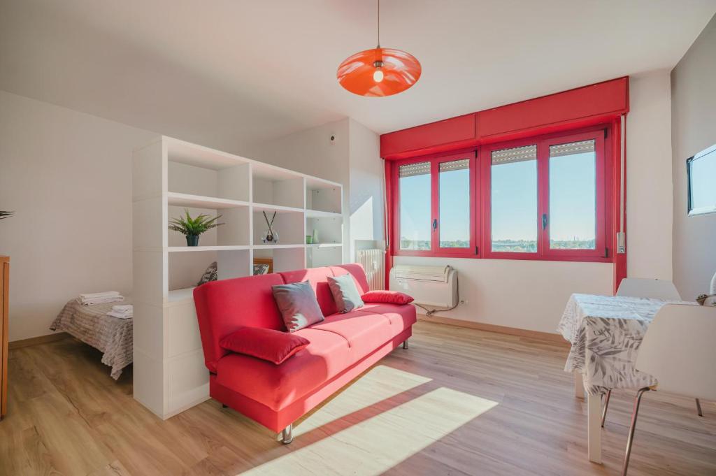 a living room with a red couch and a table at Cervino's Home - 20 min from Venice & Parking in Venice