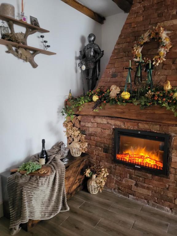 a living room with a brick fireplace with a fire at Pensiunea Plaiul Domnesc Runcu in Runcu