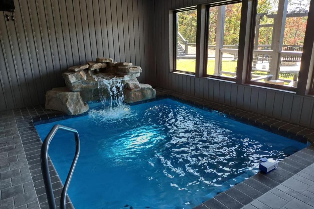 una piscina con una fuente de agua en una casa en Beartopia - Private Indoor Pool, Mountain Views, Game Room + Luxury Accommodations, en Oldham