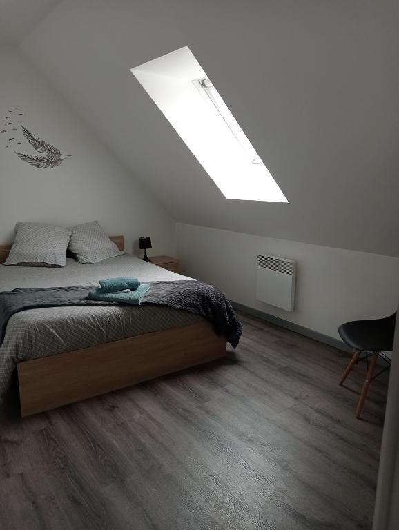 a bedroom with a bed and a skylight at La Maison LUDO in Arrest