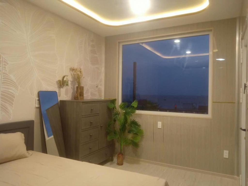 a bedroom with a window and a bed and a dresser at 49homestay in Ấp Khánh Phước (1)