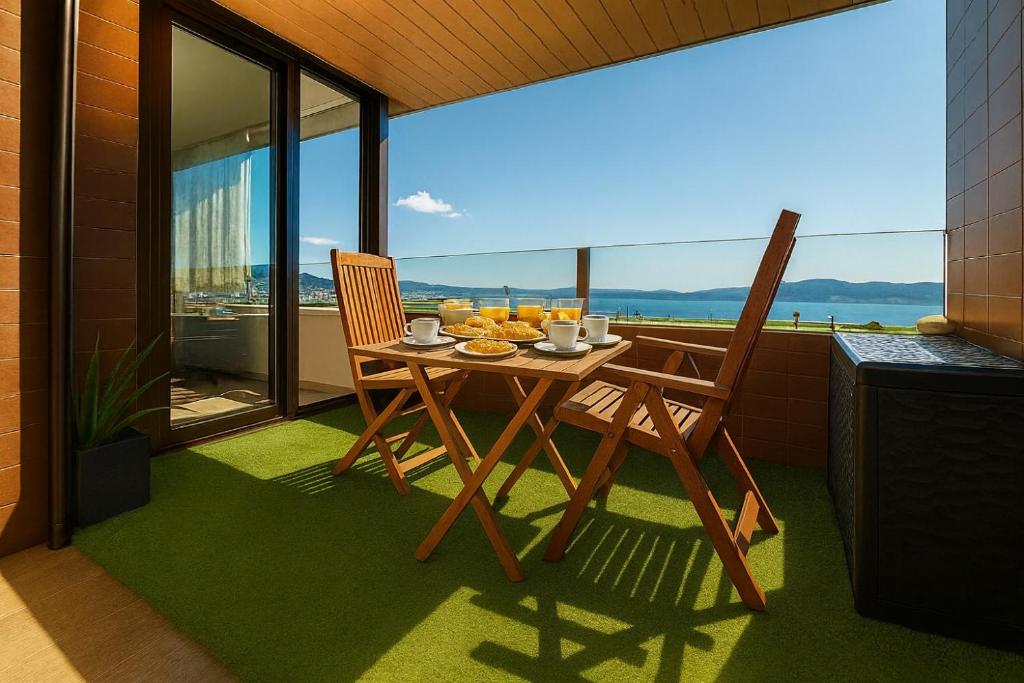 a table and chairs on a balcony with a view at Apart CityMar 24h Terraza y vistas Ria Vigo in Vigo