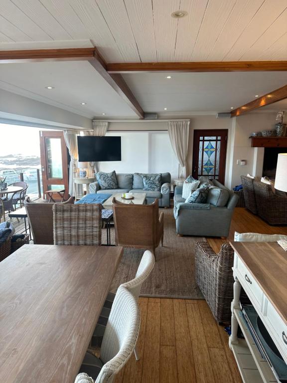 een woonkamer met een bank en een tafel bij Woelwaters Beach Villa in Herolds Bay
