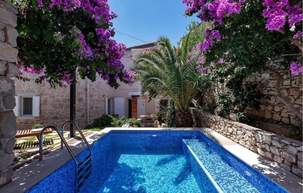 スティヴァンにあるBeautiful Home In Sutivanの紫の花が咲く庭のスイミングプール