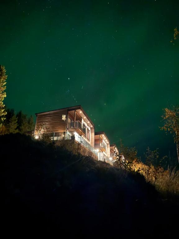 a house sitting on top of a hill at night at Modern and cozy fjord view cabin in Kjerrvika