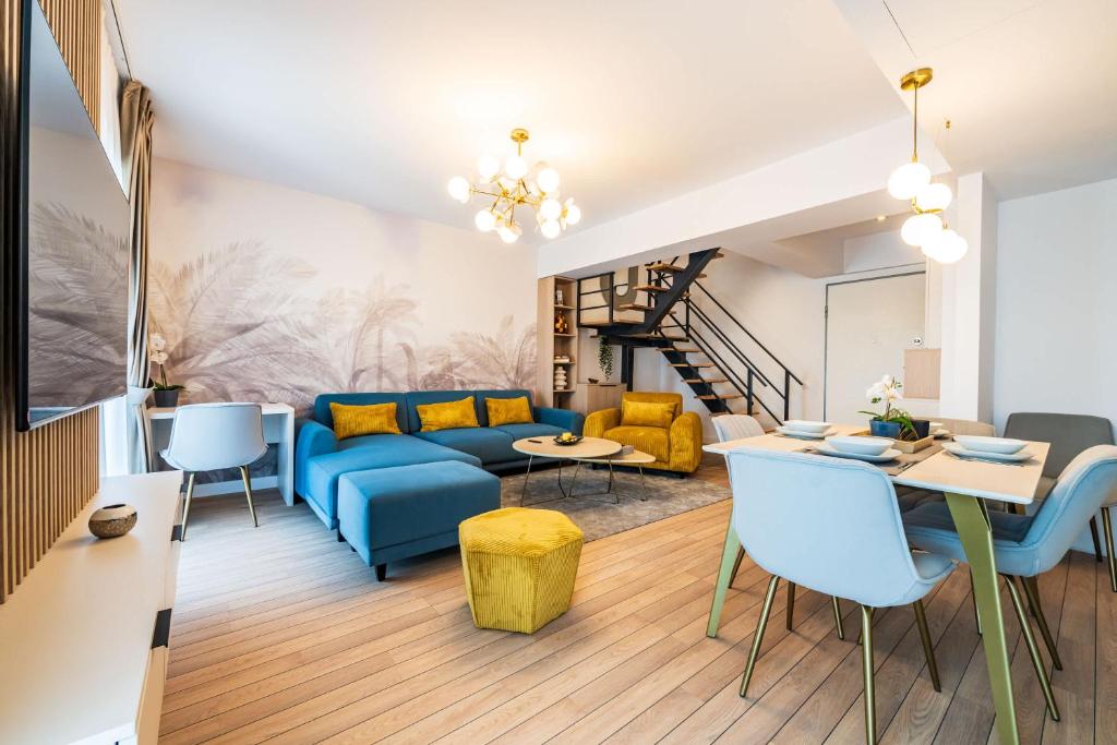 un salon avec un canapé bleu et une table dans l'établissement Panoramic Penthouse Views - Cozy 2BR Retreat, à Vatra Mînăstirii Cotroceni