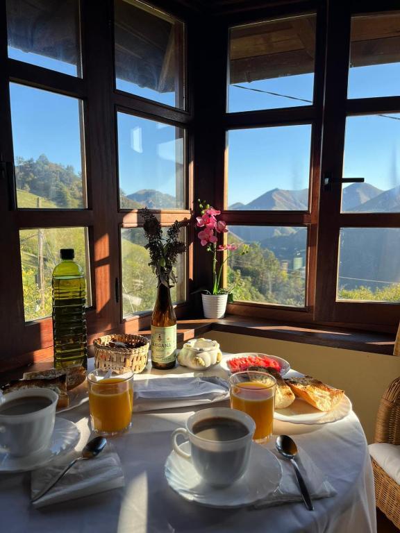 a table with food and cups of coffee and windows at Casa de Ligueria in Rozapanera