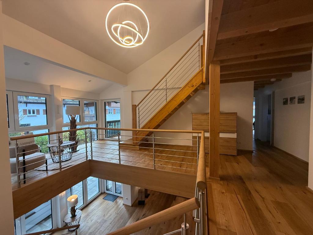 un grand escalier dans une maison avec un plafond dans l'établissement Haus Am Faltenbach - Ferienhäuser Alpenglück, à Oberstdorf