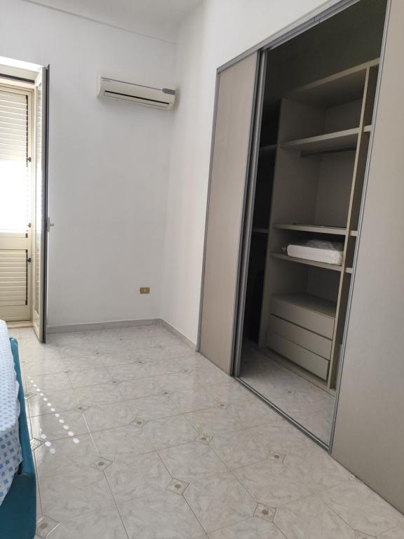 una habitación con un armario vacío con un espejo en A un passo dal cuore, en Mesagne