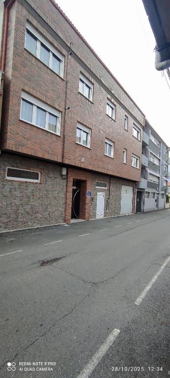 an empty street in front of a brick building at Fogar Bardanca in Melide