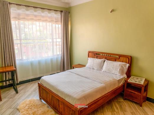 une chambre avec un lit et une grande fenêtre dans l'établissement Express living and wellness, à Jinja