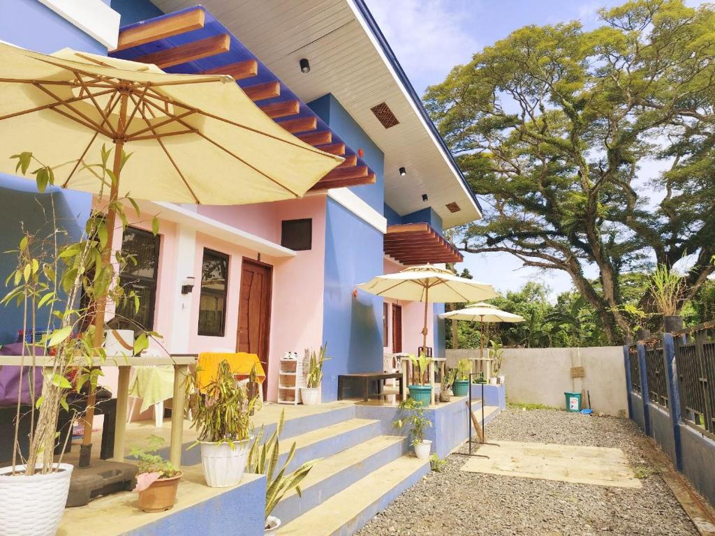 a house with two umbrellas in front of it at Amwani Azure in Puerto Princesa City