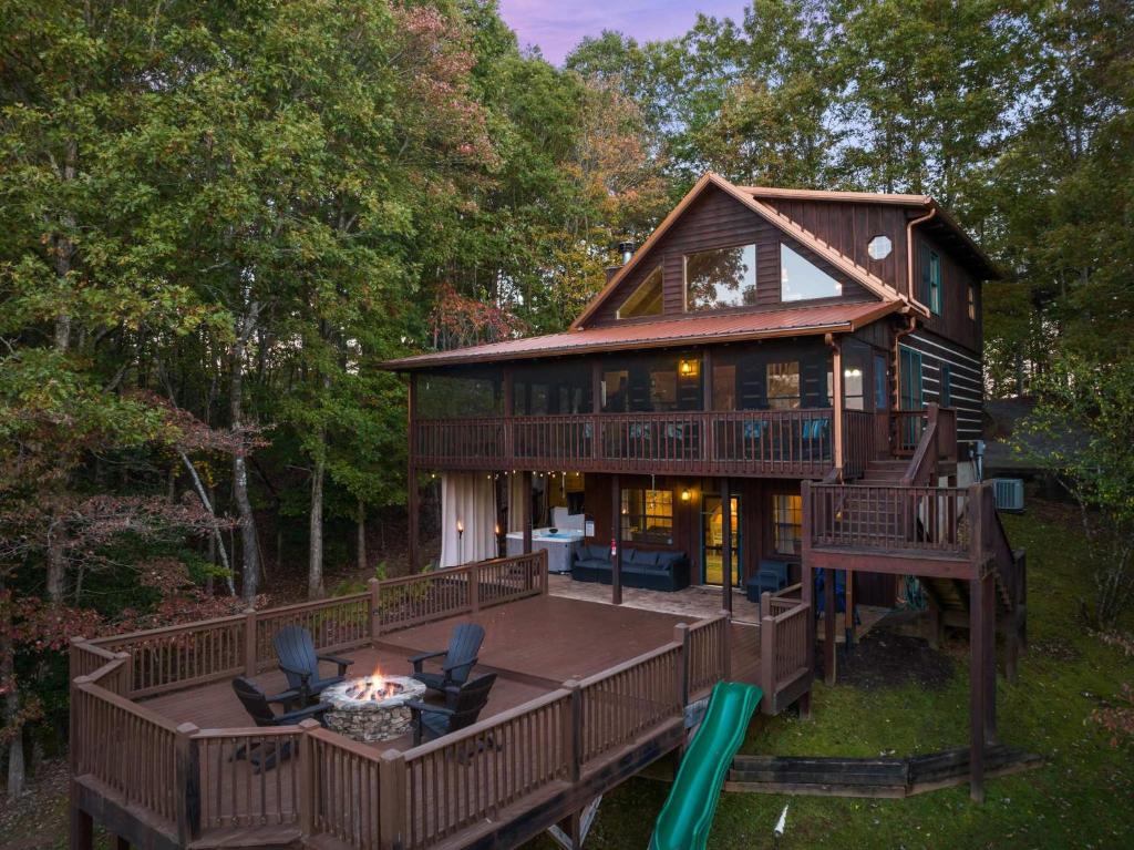 a large house with a deck and a fire pit at Mountain Cabin Escape Views Games & Relaxation in Mineral Bluff