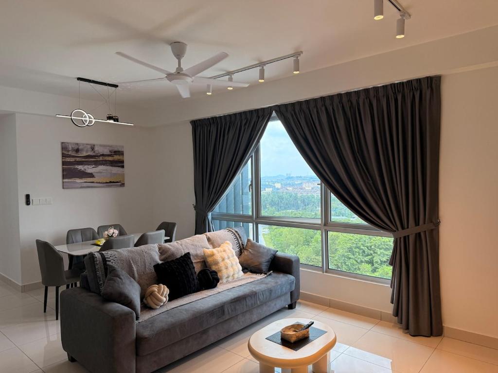 Una sala de estar con un sofá y una ventana grande. en Self Check in Mirai Kajang 3BR, en Kajang