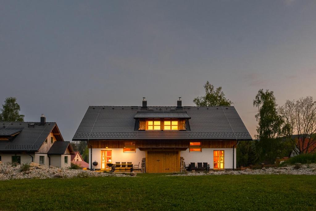 une grande maison blanche avec un toit noir dans l'établissement Gabreta apartments, à Stachy