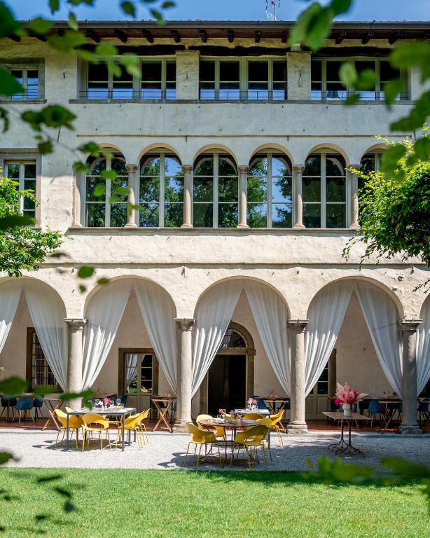 a building with tables and chairs in front of it at Locanda Scotti in Paladina