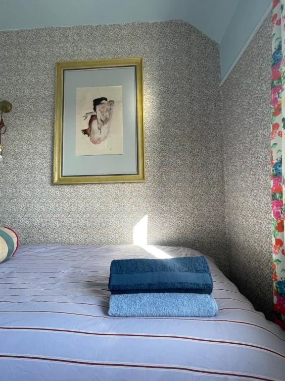 a bedroom with a bed with a picture on the wall at House of Agnes in Yeovil