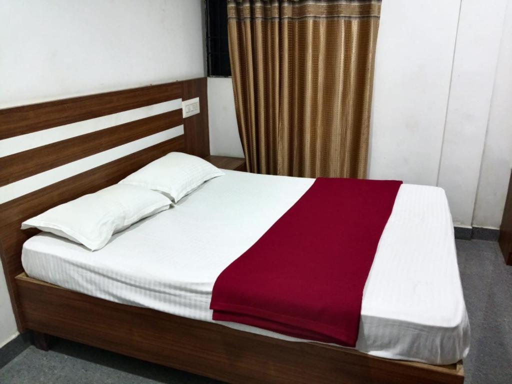 Una cama con una manta roja y blanca. en Pacio Residency, en Kanchipuram