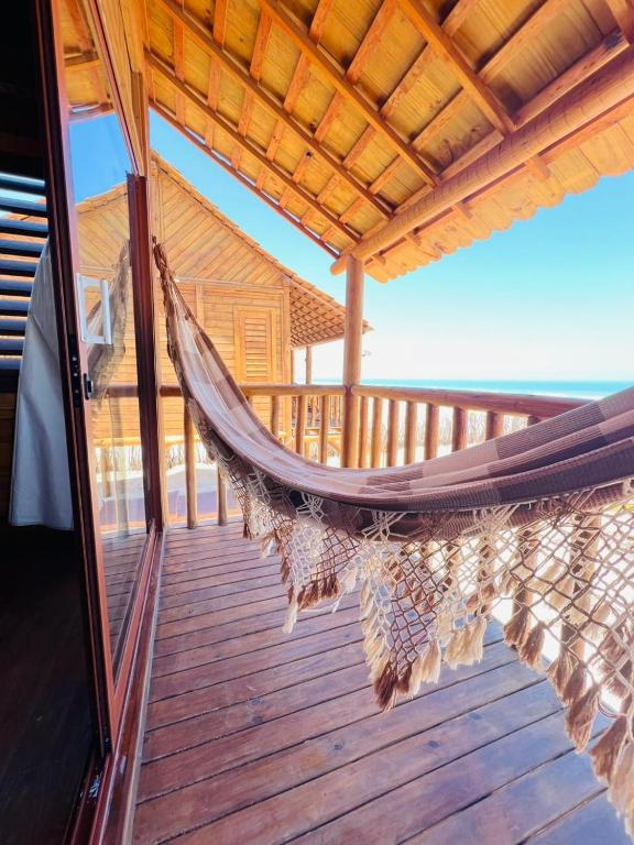 a hammock on the deck of a house at Chalet Paraiso Canoa 3 na praia - Canoa Quebrada in Aracati