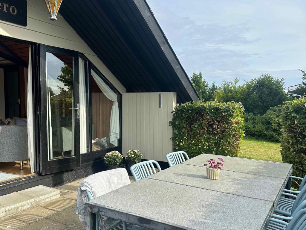 a table and chairs on the patio of a house at Cozy Summer House With New Kitchen And Bathroom in Karrebæksminde