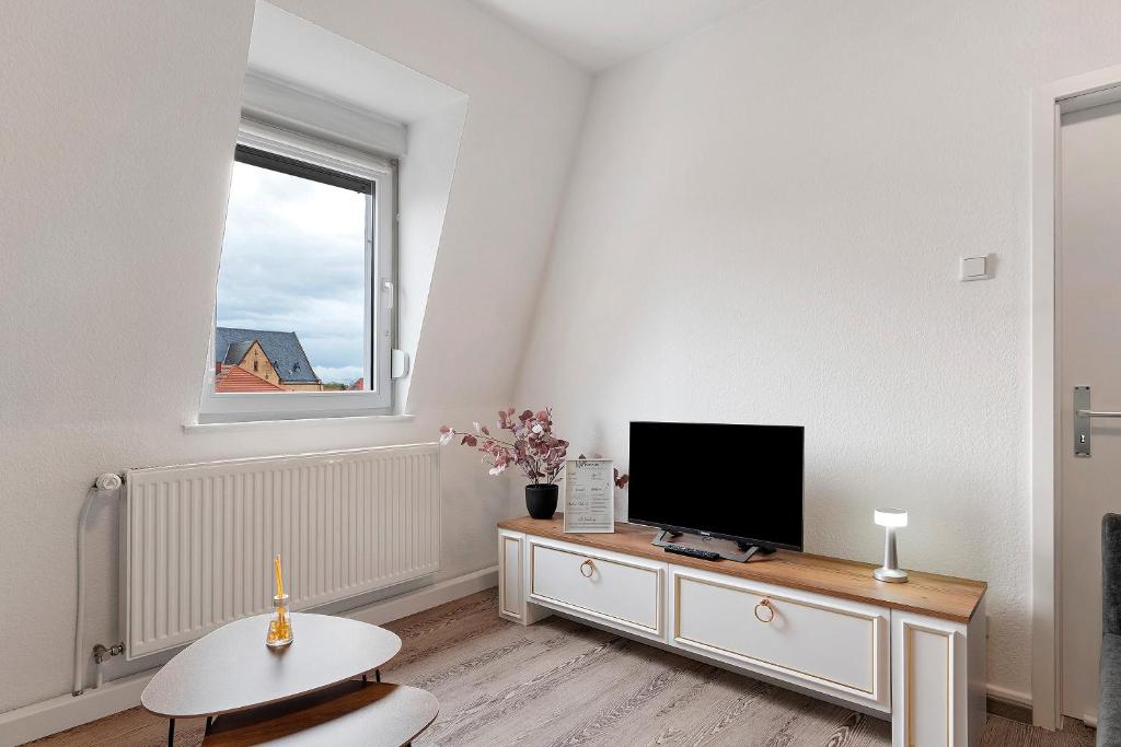 a living room with a flat screen tv on a dresser at Az-Living Feudenheim in Feudenheim