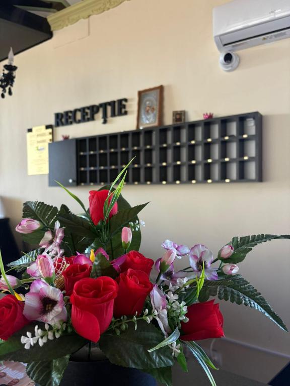 a bouquet of red roses sitting on a table at Hotel Abi in Baile Felix