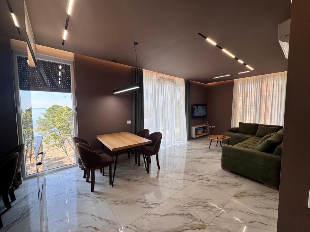 レジャにあるSunset Luxury Apartment Shengjinのテーブルとソファのあるリビングルーム