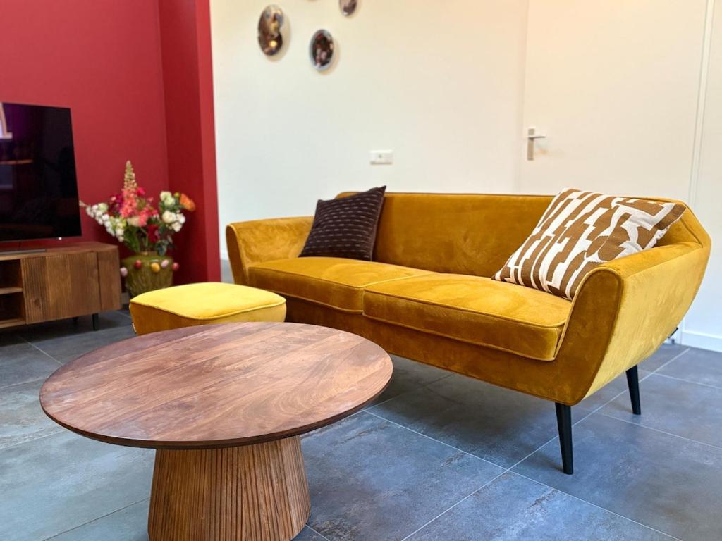 ein Wohnzimmer mit Sofa und Tisch in der Unterkunft Sfeervolle villa met sauna aan de rand van het bos in Putten