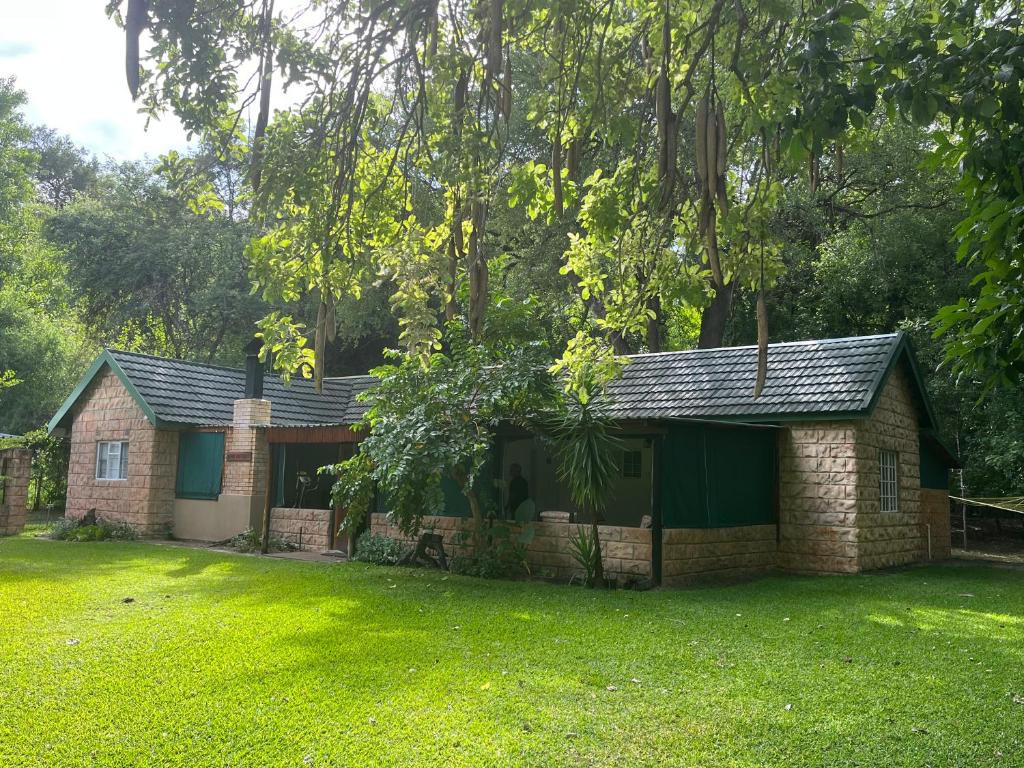 a brick house in a yard with a green lawn at Proudly Okavango self-catering Burnside in Shakawe