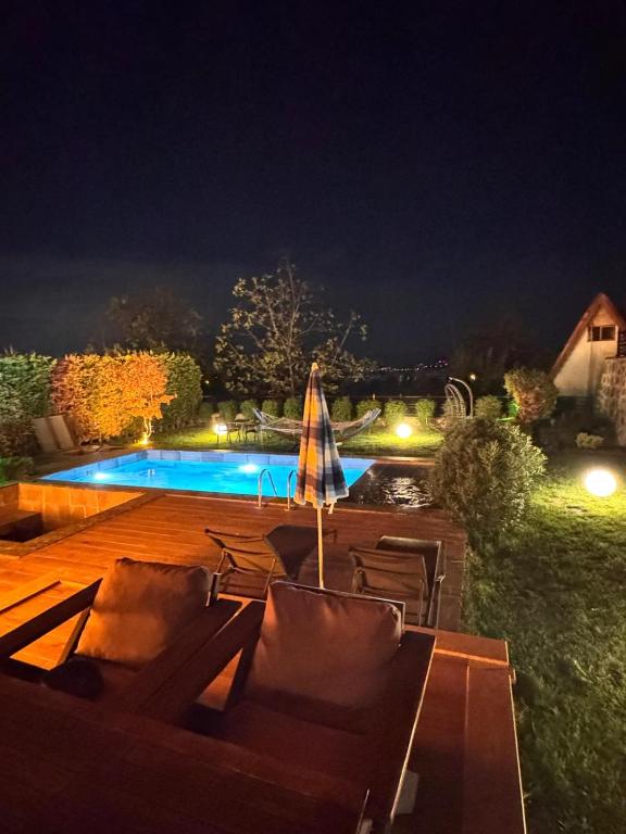 een zwembad met stoelen en een parasol bij Real Love Villas in Sakarya