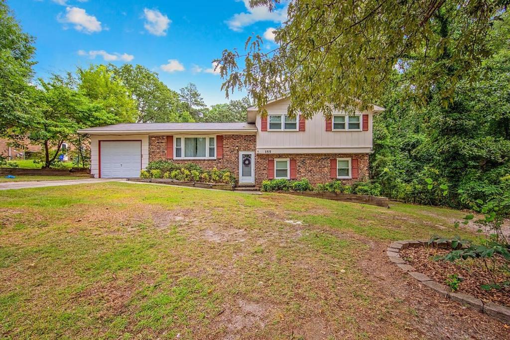 a brick house with a garage and a yard at Reilly Road Refuge in Fort Bragg