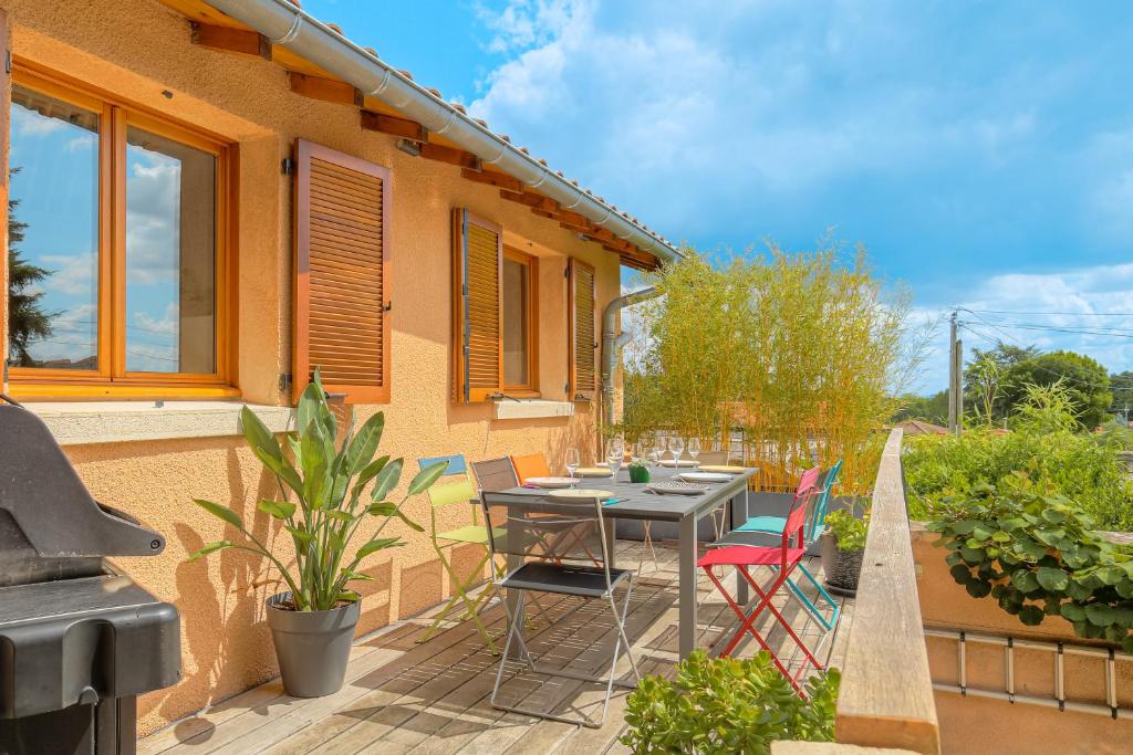 a patio with a table and chairs and a grill at Les Aubépines en Beaujolais in Salles-Arbuissonnas