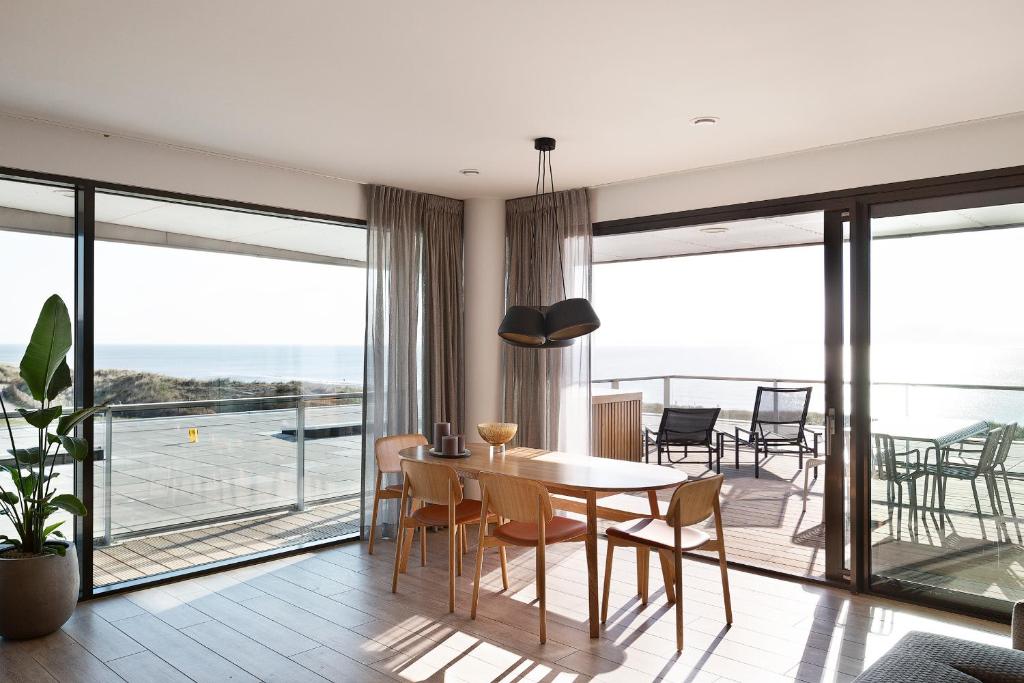 ein Esszimmer mit Blick auf das Meer in der Unterkunft Droomsuites Egmond aan Zee 4 personen by Droomvilla in Egmond aan Zee