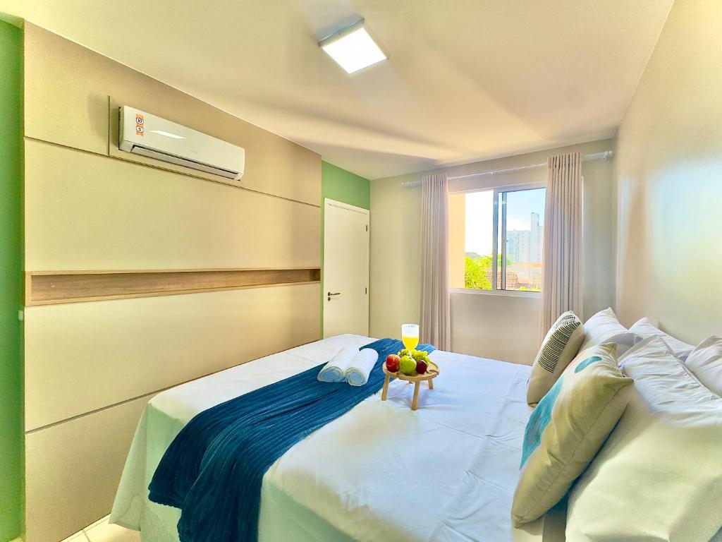 a bedroom with a large white bed and a window at Aptos em Bal Piçarras a150m da PRAIA, dois quartos, sala de estar, COZINHA COMPLETA, SACADA com CHURRASQUEIRA, WI-FI, PISCINA, PORTARIA 24h, PLAYGROUND e QUADRA DE ESPORTES in Piçarras