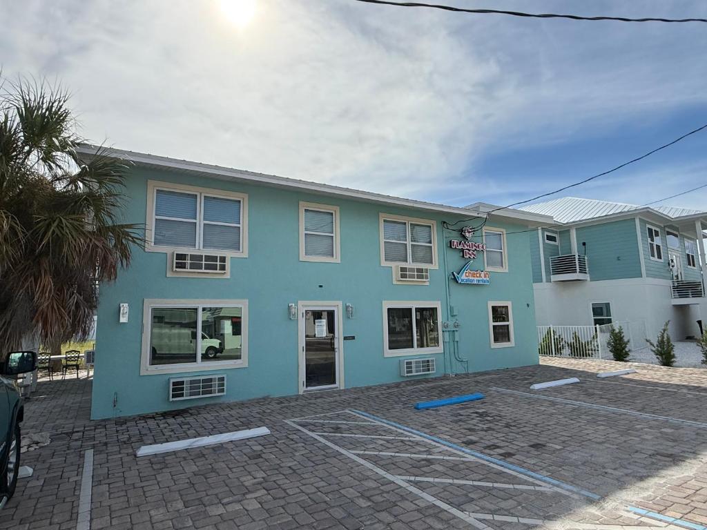 a blue building with a parking lot in front of it at Flamingo Inn in Fort Myers Beach